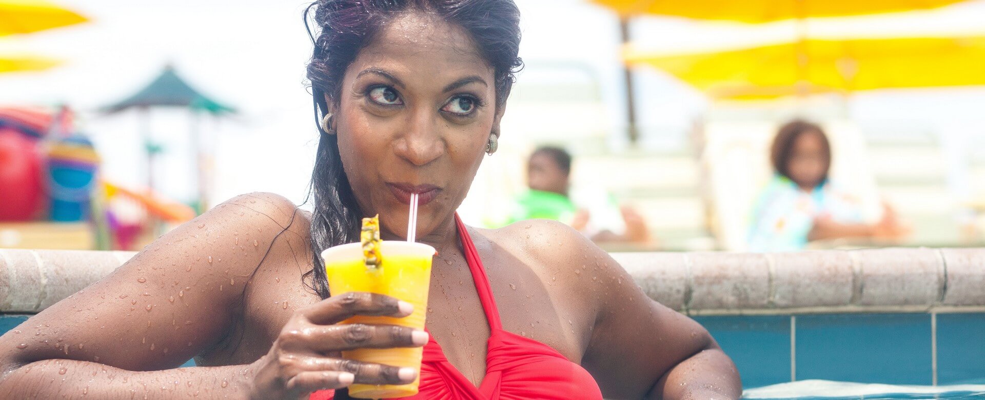 woman in Sirata pool with cocktail